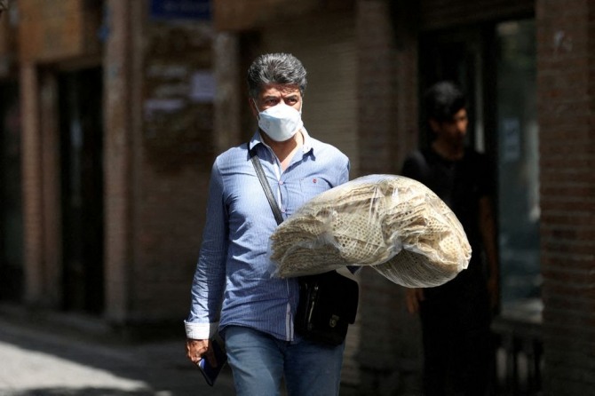 이란에서 전통 빵을 봉지에 담아 옮기고 있는 남자. 사진=로이터