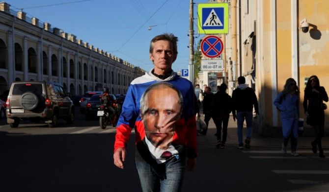 러시아에서 푸틴을 반대하는 여론이 확산되고 있다. 러시아 상트페테르부르크에서 블라디미르 푸틴 러시아 대통령의 모습이 그려진 셔츠를 입은 남성이 길을 건너고 있다. 사진=로이터