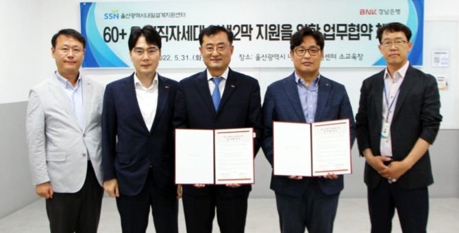 BNK경남은행 박태규 상무(왼쪽 세번째)와 울산시내일설계지원센터 김명진 센터장(오른쪽 두번째)이 '60+ 은·퇴직자 인생2막 지원 업무 협약'을 체결하고 기념사진을 촬영하고 있다. [사진=BNK경남은행]