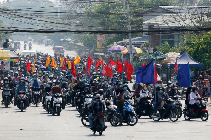 지난 3월 25일 미얀마 만달레이에서 깃발을 든 쿠데타 반대 시위대가 오토바이를 몰고 행진하고 있다. 사진=뉴시스