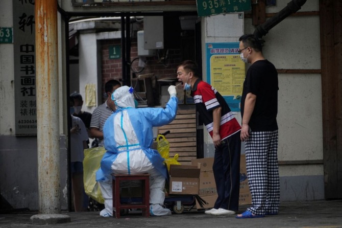 상하이에서 한 시민이 코로나 검사를 받고 있다. 사진=로이터