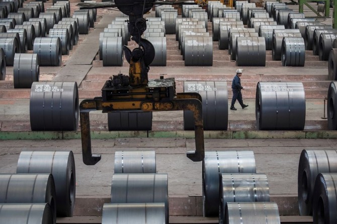 중국의 철강공장에서 노동자가 철강 사이를 지나가고 있다. 사진=로이터