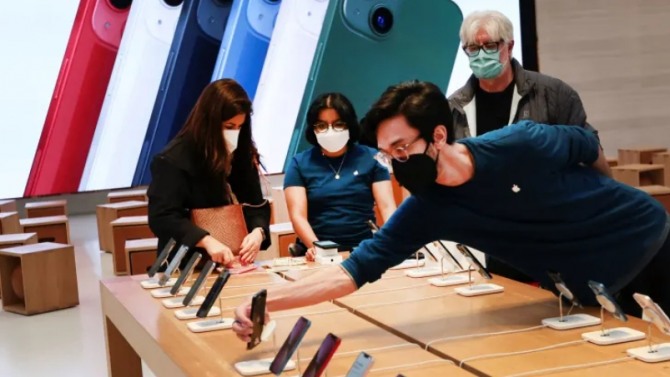 애플 스토어 매장에서 직원이 진열된 아이폰을 살피고 있는 모습. 사진=로이터