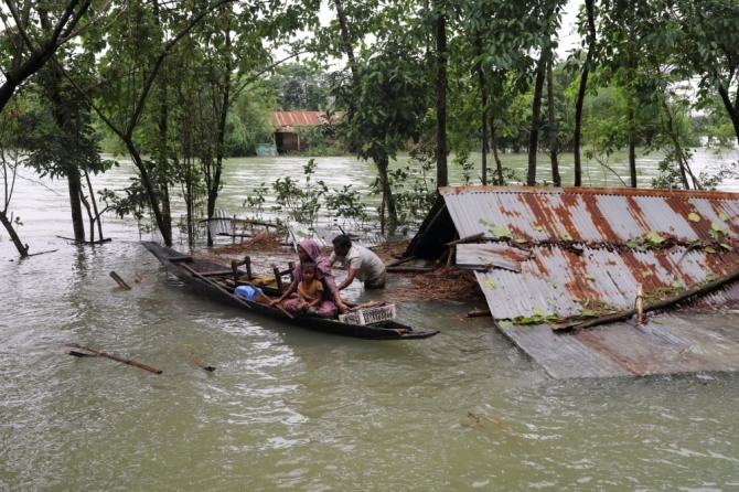 사람들은 방글라데시 실레트에 홍수가 퍼지는 동안 보트를 타고 피난처를 찾고 있다. 사진=로이터