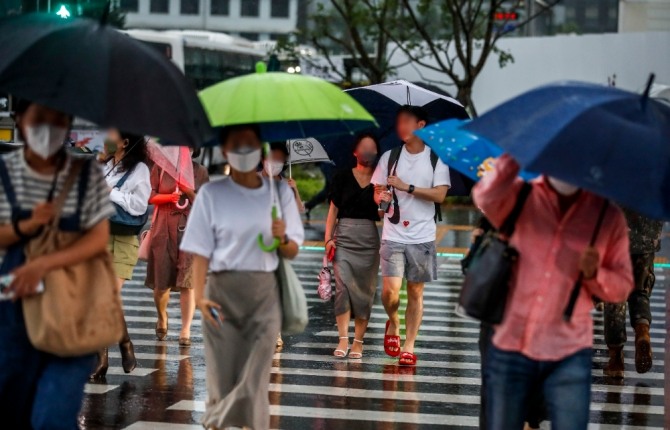 23일 오후 서울 종로구 광화문광장 인근에서 내리는 폭우에 시민들이 우산을 쓴 채 이동하고 있다. 사진=뉴시스