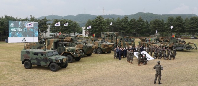 4륜형 장갑차 등 국방 수송장비를 배경으로 군 관계자들이 기념 촬영을 하고 있다. 사진=뉴시스