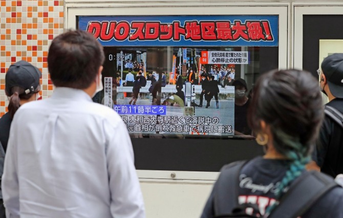  8일 일본 도쿄에서 시민들이 TV를 통해 아베 신조 전 총리의 피격 소식을 지켜보고 있다. 아베 전 총리는 나라에서 참의원 선거를 앞두고 선거 유세 중 총성과 함께 가슴 부위에 피를 흘리며 쓰러져 심정지 상태로 병원으로 옮겨졌다. 사진=뉴시스