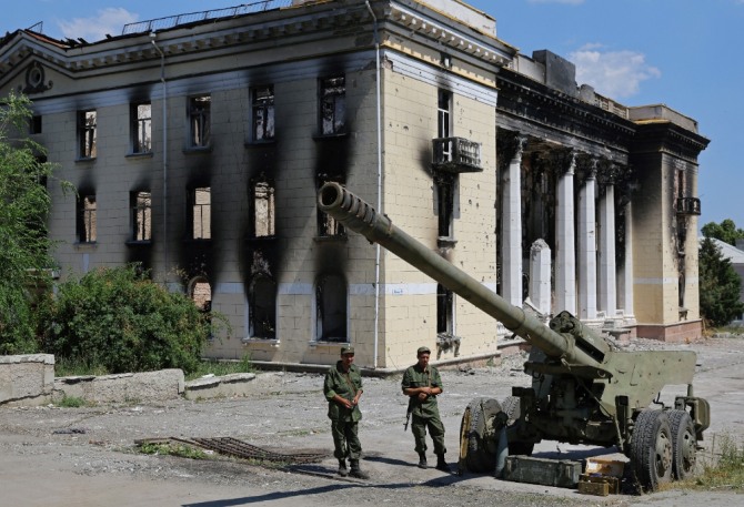 친러시아군 병사들이 7월 8일 우크라이나 루한스크주 리시찬스크에서 철수 후 도시에 남겨진 우크라이나군 포탄총 옆에 서 있다. 세계 각국은 러시아의 우크라이나 침공을 계기로 군비를 확대하고 있다. 사진=로이터