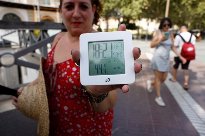 유럽의 한 여성이 온도계에 찍힌 기온 44.4도씨를 보여주고 있다. 사진=로이터