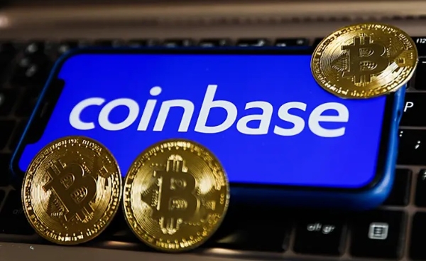 코인베이스 로고가 띄워진 휴대폰과 비트코인 로고가 새겨진 동전들. 사진=게티이미지뱅크