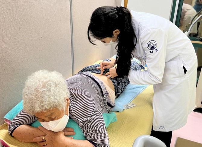 부천자생한방병원 의료진이 임시진료소를 방문한 환자에게 침 치료를 실시하고 있다. 사진=자생한방병원