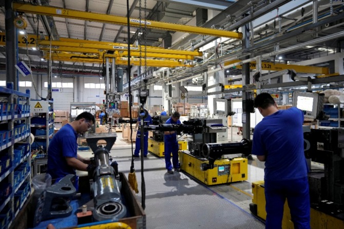 코로나 바이러스 질병 발생 이후 독일 엔지니어링 그룹이 중국 자동차 부품 공장을 방문하는 동안 직원들이 생산 라인에서 일하고 있다. 사진=로이터