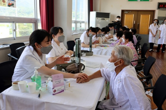 신협 2022년 하계 한방의료봉사’에서 장수군민이 경희대학교 의료봉사단원에게 진료를 받고 있는 모습 [사진=신협중앙회]