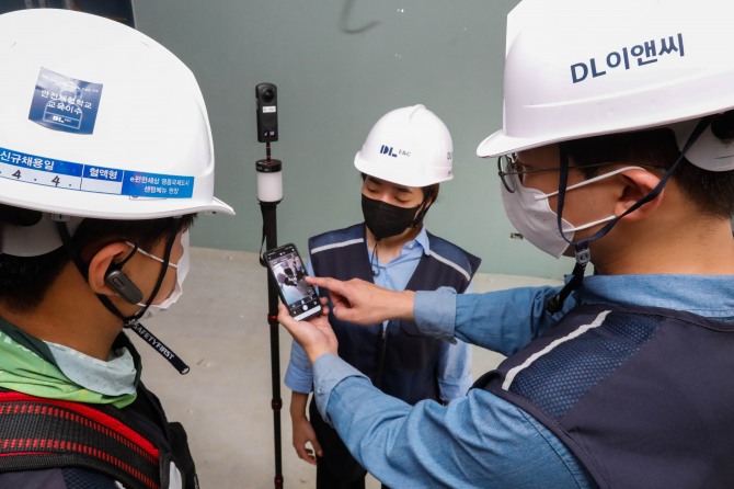 DL이앤씨 직원들이 360도 카메라로 촬영한 공동주택 건설현장의 시공 품질을 점검하고 있다. 사진=DL이앤씨