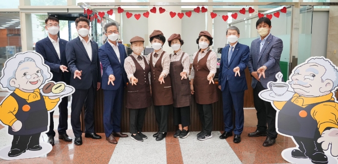 BNK경남은행 영업부 내 실버카페 '카페아리' 오픈식에 참석한 BNK경남은행 김영원(오른쪽 두 번째) 그룹장과 카페아리 소속 어르신 등이 기념촬영하고 있다. 사진=BNK경남은행