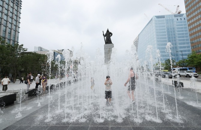 서울 광화문광장이 개장한 6일 오전 어린이 등이 분수대에서 더위를 식히고 있다. 사진=연합뉴스