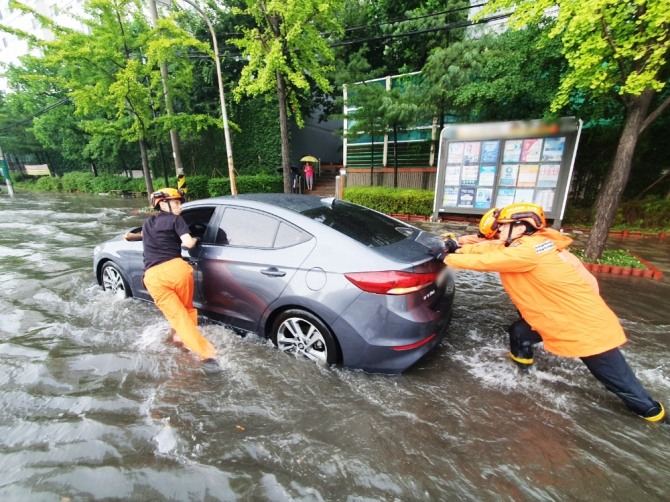 8일 오후 인천에 강하게 내린 비로 인해 미추홀구 용현동 한 도로에서 차량이 침수돼 신고를 받고 출동한 소방당국이 안전조치를 하고 있다. 사진=뉴시스, 인천소방본부