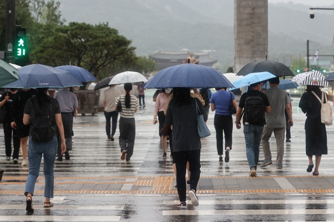  지난 8일 오전 출근시간 시민들이 서울 종로구 광화문역 인근에서 우산을 쓰고 걷고 있다. 사진=연합뉴스