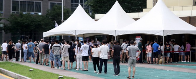 광복절 연휴에도 코로나19 확산세가 이어진 14일 오전 서울 송파구보건소 선별진료소에서 시민들이 코로나19 검사를 받기 위해 길게 줄지어 서 있다. 사진=뉴시스