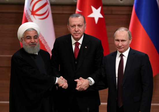 튀르키예(터키)에서 이란 전 대통령(왼쪽)과 손잡은 푸틴 대통령(오른쪽). 사진=로이터