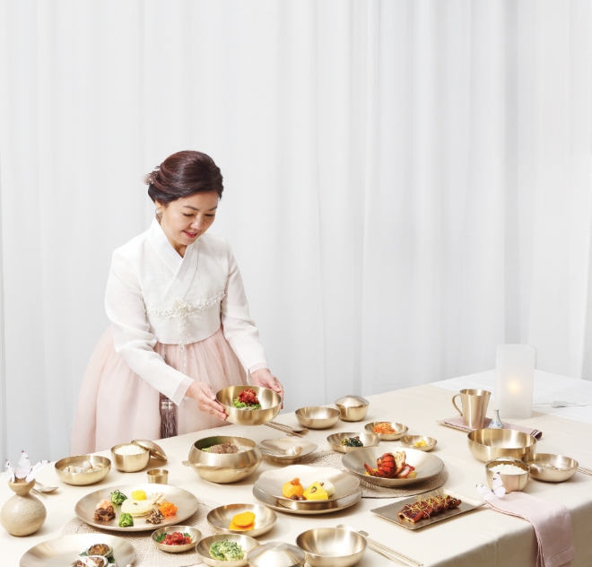 이윤정 금마유기공예 대표가 자사 유기그룻에 담은 식사 차림상을  차리고 있다. 사진=금마유기공예