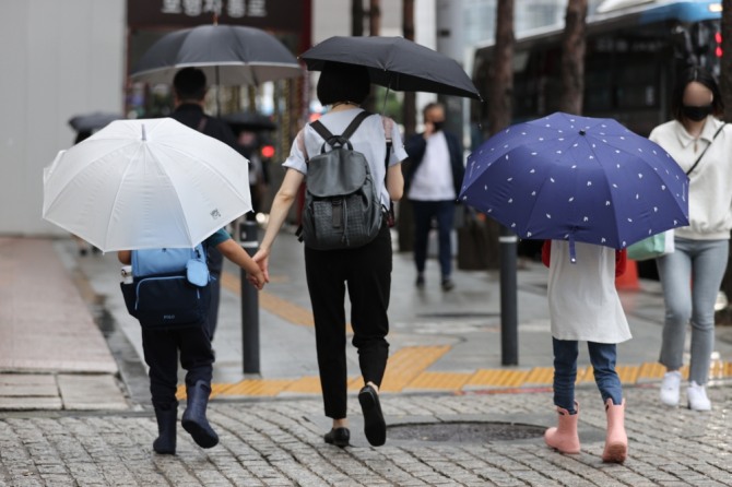비가 내리며 아침기온이 21도까지 떨어진 8월 29일 오전 우산을 쓴 어린이들이 서울 중구 을지로입구역 인근에서 엄마 손을 잡고 걷고 있다.사진=연합