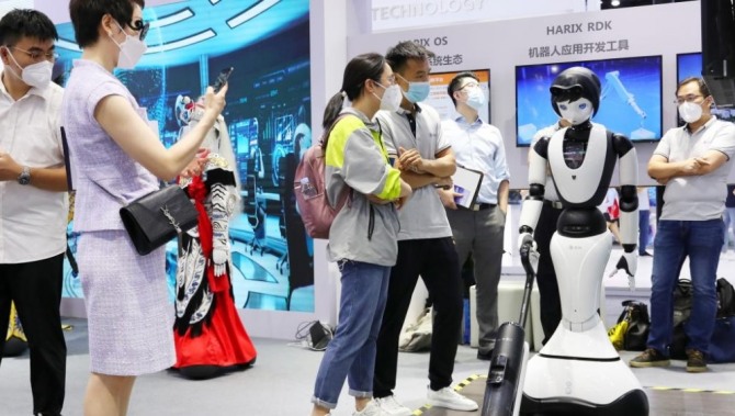 중국 상하이에서 개최된 세계 인공지능 컨퍼런스에서 참가자들이 로봇을 구경하고 있다. 사진=신화/뉴시스