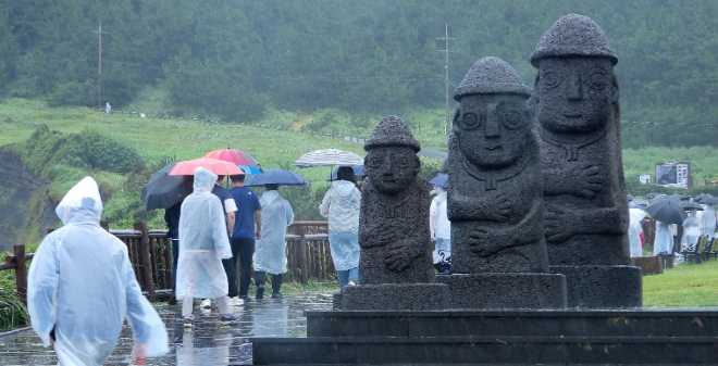 제11호 태풍 '힌남노' 간접영향으로 비가 내리는 2일 오후 제주 서귀포시 대정읍 송악산에 우산을 쓴 관광객들이 걸어가고 있다. 사진=뉴시스