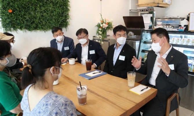 오화경 저축은행중앙회장(오른쪽)이 자영업사장님들과 대화를 나누고 있는 모습. [사진=저축은행중앙회]
