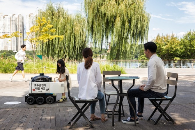실내외 배달로봇 딜리 드라이브가 경기도 수원 광교호수공원에서 음료를 배달하고 있다. 사진=우아한형제들