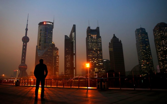 최근 중국 경제 분위기를 보여주는 듯한 어둠이 깔리고 있는 중국 상해 푸동 금융지구를 바라보고 있는 한 남자 모습. 사진=로이터
