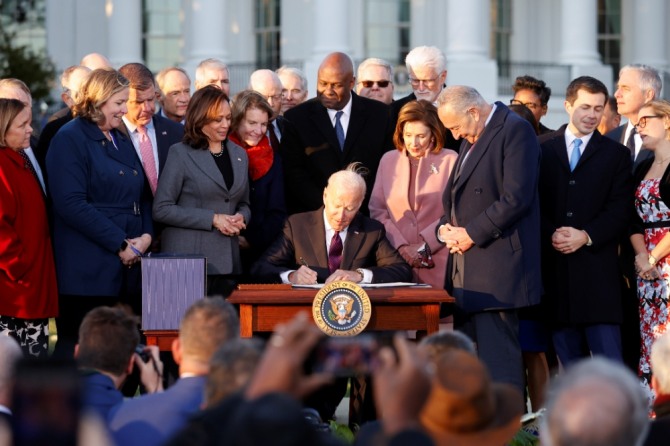 조 바이든 미국 대통령이 지난해 11월 15일(현지시간) 백악관에서 각료들이 지켜보는 가운데 앞서 미 의회에서 통과시킨 ‘인프라 투자 및 일자리 법안’에 서명하고 있다. 사진=로이터