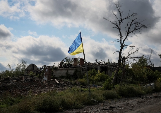 23일(현지 시각) 우크라이나 돌리나에서 러시아의 우크라이나 공격이 계속되면서 파괴된 건물 근처에서 우크라이나 국기가 펄럭이고 있다. 사진=로이터