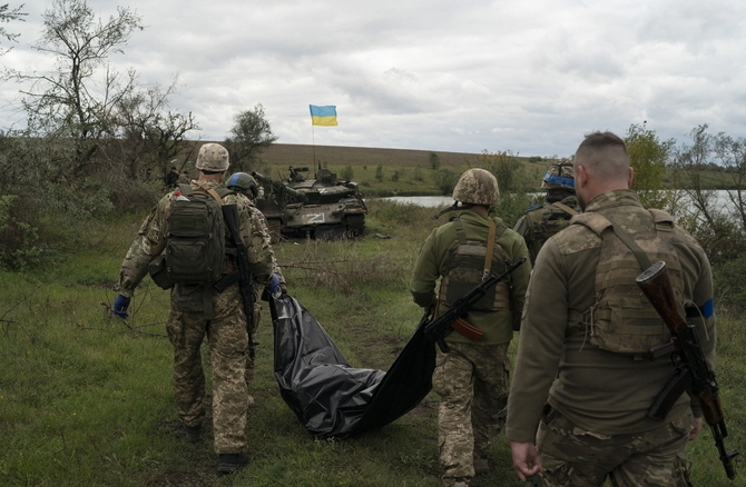 지난 19일(현지시간) 우크라이나 하르키우주 러시아와의 국경 인근 지역에서 우크라이나 방위군이 작전 중 찾아낸 우크라이나군 병사의 시신을 옮기고 있다. [사진=뉴시스]