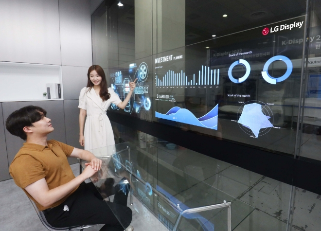 지난 8월 서울 코엑스에서 열린 'K-디스플레이 2022'에서 LG디스플레이 모델이 '회의실용 투명 OLED 솔루션'을 사용하고 있다. 사진=LG디스플레이    