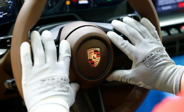독일 슈투트가르트의 포르쉐 제조공장에서 운전대에 포르쉐 로고를 부착하는 모습. 사진=로이터