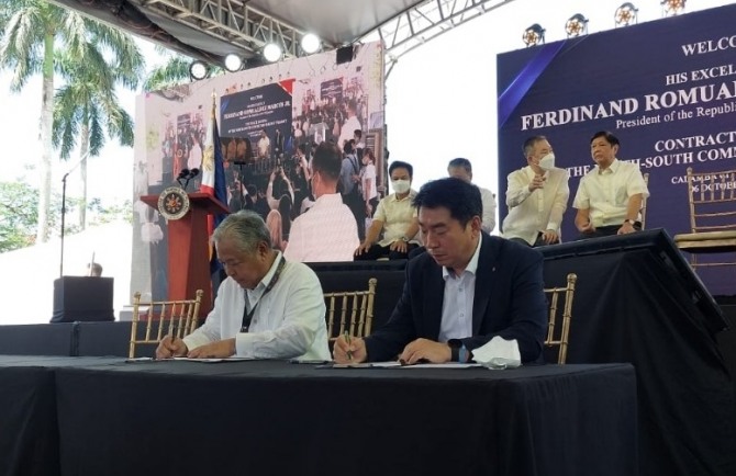제이미 바티스타 필리핀 교통부장관(왼쪽)과 롯데건설 김종수 토목사업본부장이 계약서에 서명하고 있는 모습. 사진=롯데건설