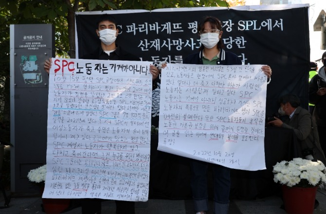 20일 오후 서울 양재동 SPC 본사 앞에서 열린 평택 SPC 계열사 SPL의 제빵공장 사망 사고 희생자 서울 추모행사에서 성공회대 노학연대모임 가시 관계자가 대자보를 펼치고 있다. 사진=연합뉴스