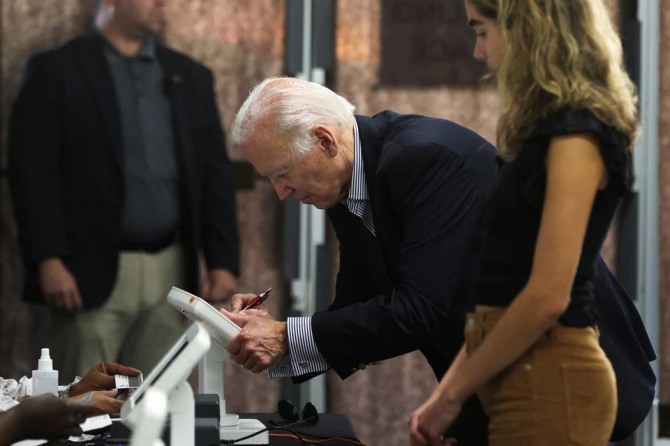 미국 조 바이든 대통령이 그의 손녀 나탈리와 함께 중간선거 조기 투표를 하러 델라웨어주 윌밍턴 한 투표장에 들어선 모습. 사진=로이터