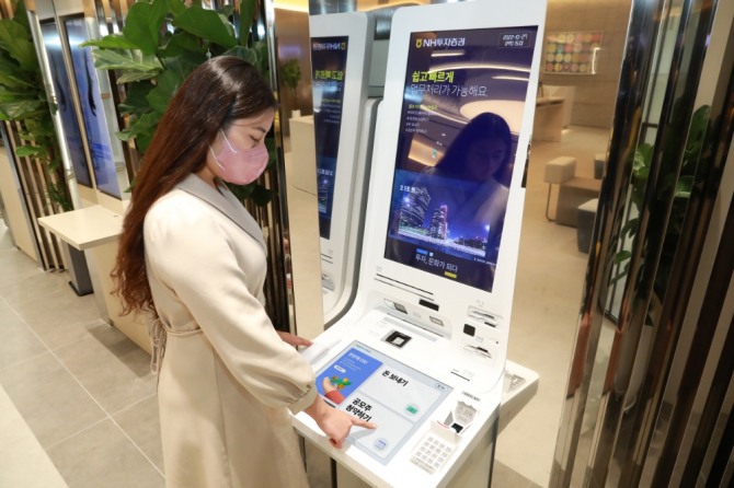 NH투자증권 강남금융센터에 설치된 STM 기기 모습. 고객이 STM기기를 사용하고 있다. 사진=NH투자증권