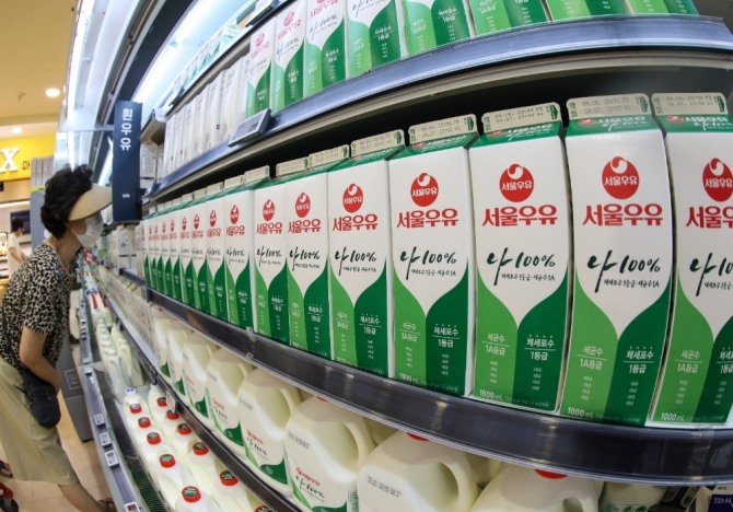 소비자가 매장의 우유를 살펴보고 있다.사진=자료