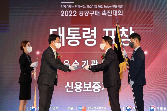 김충배 신용보증기금 전무이사(오른쪽)가 지난 24일 '2022 공공구매촉진대회'에서 조주현 차관으로부터 공공구매 유공 대통령 표창을 수여받고 있다.사진=신용보증기금