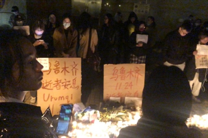 11월 26일 밤 (현지시간) 중국 상하이 시내의 코로나19봉쇄 반대 시위대가 중국 신장의 한 아파트 화재로 숨진 10명의 영혼을 위로하는 집회를 갖고 있다. 사진=AP/뉴시스.