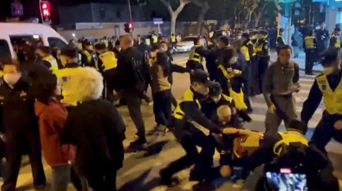 경찰관들이 2022년 11월 27일 중국 상하이 우루무치 화재 희생자들을 위한 촛불집회 현장에서 코로나 바이러스병 억제 시위를 하던 중 사람들을 구금하고 있다. 사진=로이터