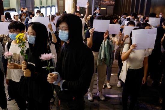 홍콩시민들이 28일(헌시 시각) 우루무치 화재 희생자 추모 행사에서 중국 본토의 코로나바이러스(COVID-19) 규제에 항의하는 흰 종이를 들고 있다.사진=로이터
