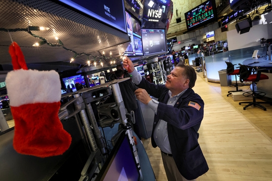 29일(현지 시각) 뉴욕증권거래소(NYSE)의 한 트레이더가 크리스마스 장식을 걸고 있다. 사진=로이터