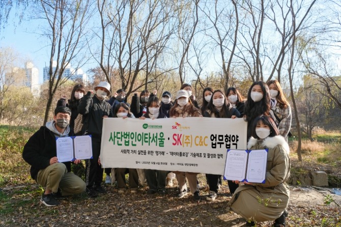 6일 서울 여의도 샛강생태공원에서 열린 ‘ESG가치 창출 확산 위한 행가래-데이터플로깅 제휴 협약식’ 후 SK㈜ C&C 강지현 매니저(왼쪽 하단), 이타서울 한유사랑 대표이사(오른쪽 하단)와 플로깅 참여 청년들이 기념 사진을 찍는 모습. 사진=SK C&C