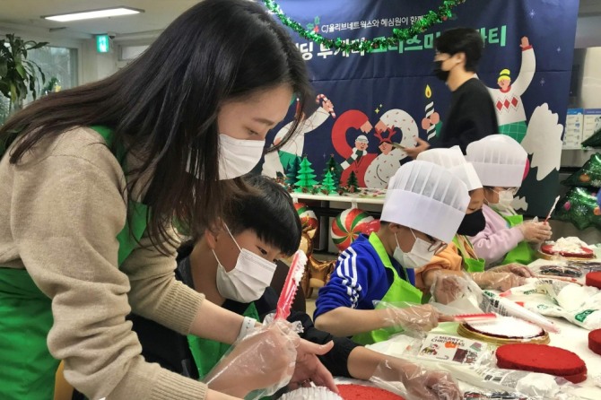 CJ올리브네트웍스 임직원이 결연 사회복지기관에서 아이들과 함께 크리스마스 케이크를 만들고 있다. 사진=CJ올리브네트웍스