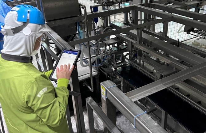 풀무원 현장 작업자가 태블릿 PC를 통해 품질 관련 데이터를 확인하고 있다. 사진=풀무원.