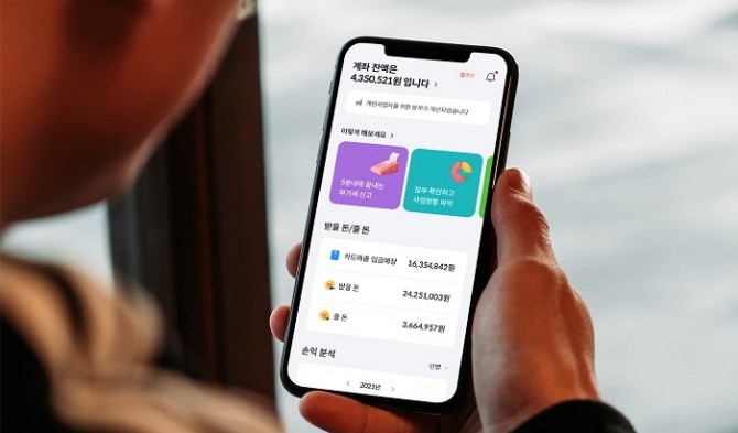 사진=‘모두의회계’의 간편 회계관리 앱 ‘머니핀’을 사용자가 들여다보고 있다. 제공=모두의회계